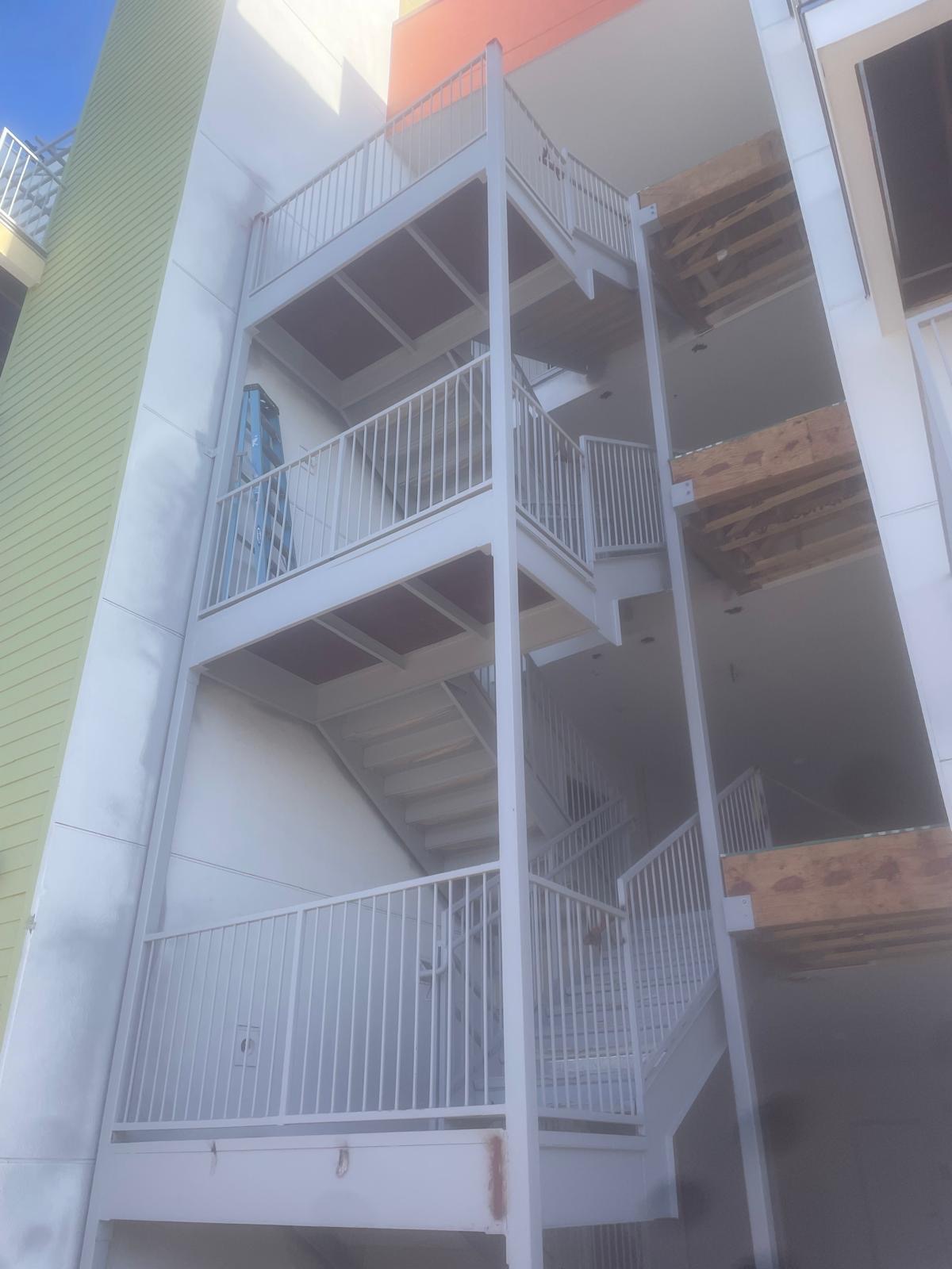 Steel egress stair with pan-filled treads and landings by Yellow Rose Steel